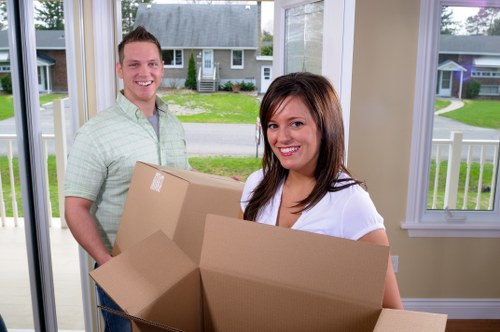 Local movers carrying furniture through a Kentishtown residential building